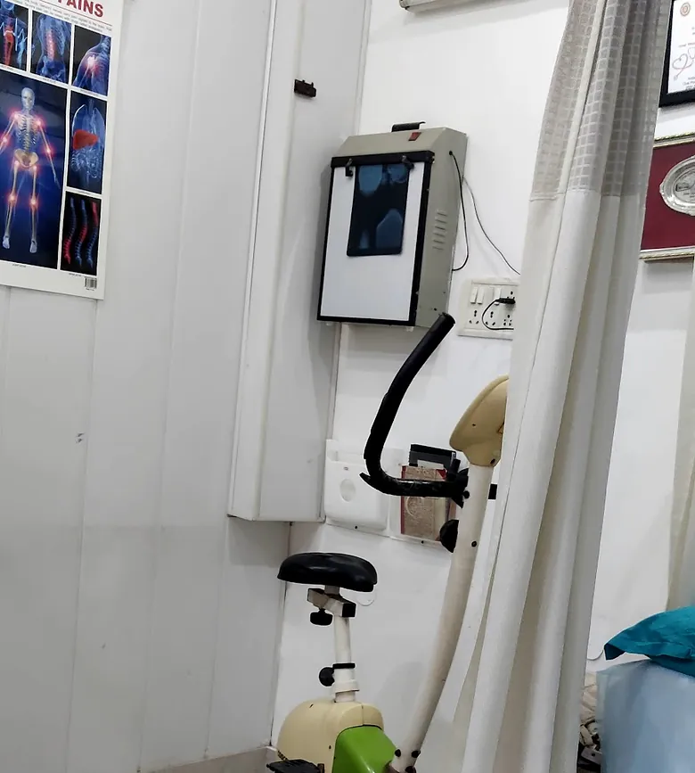 A corner of the treatment room: exercise cycle, X-ray viewer and a spine chart.
