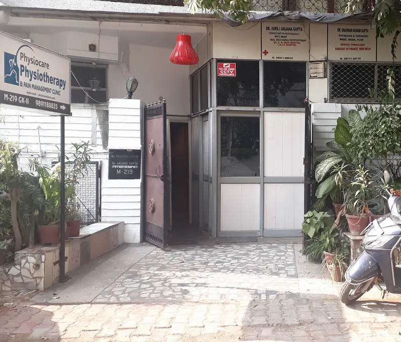 The entrance at M-219 Greater Kailash II, with the Physiocare Physiotherapy signboard and the doctors' name boards.